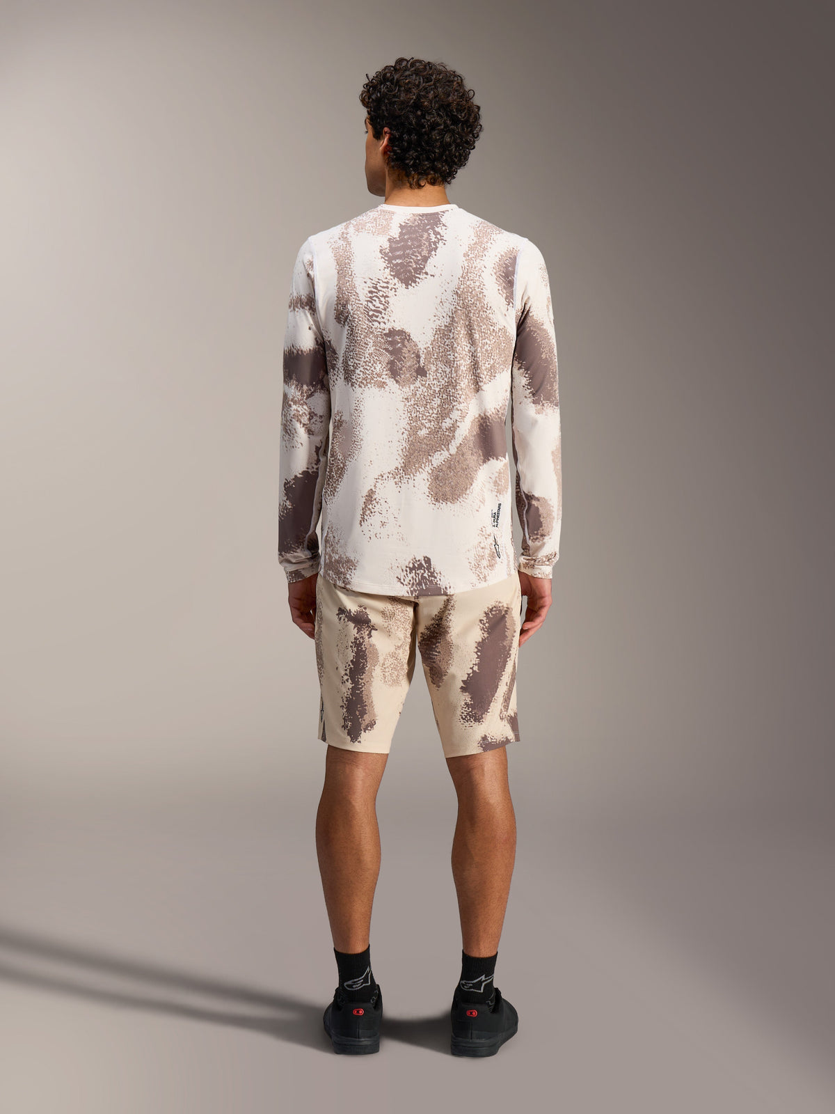 Alpinestars A-Dura Ride LS jersey en shorts in sand camo, complete MTB-outfit, achteraanzicht.