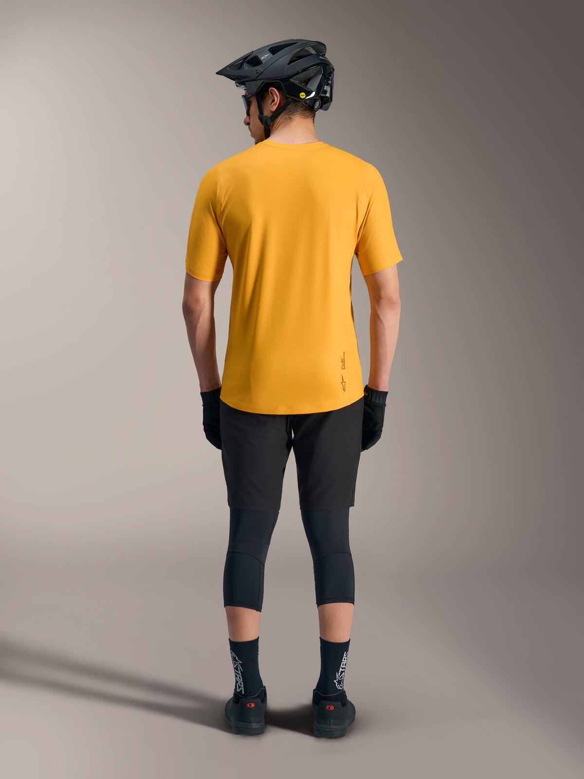 Oranje A-Dura Ride fietsshirt met korte mouwen, achteraanzicht met verlengde achterkant en logodetail voor MTB-stijl.