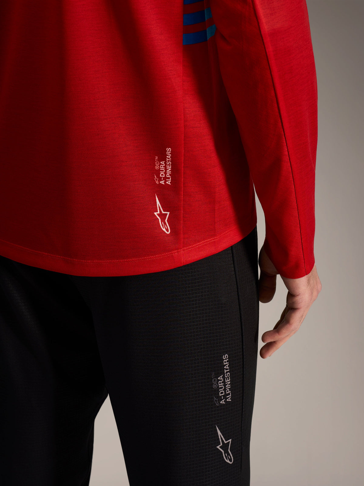 Rode A-Dura Elite 2.0 jersey met lange mouwen en zwarte MTB-broek met Alpinestars-logo's en technische stof.