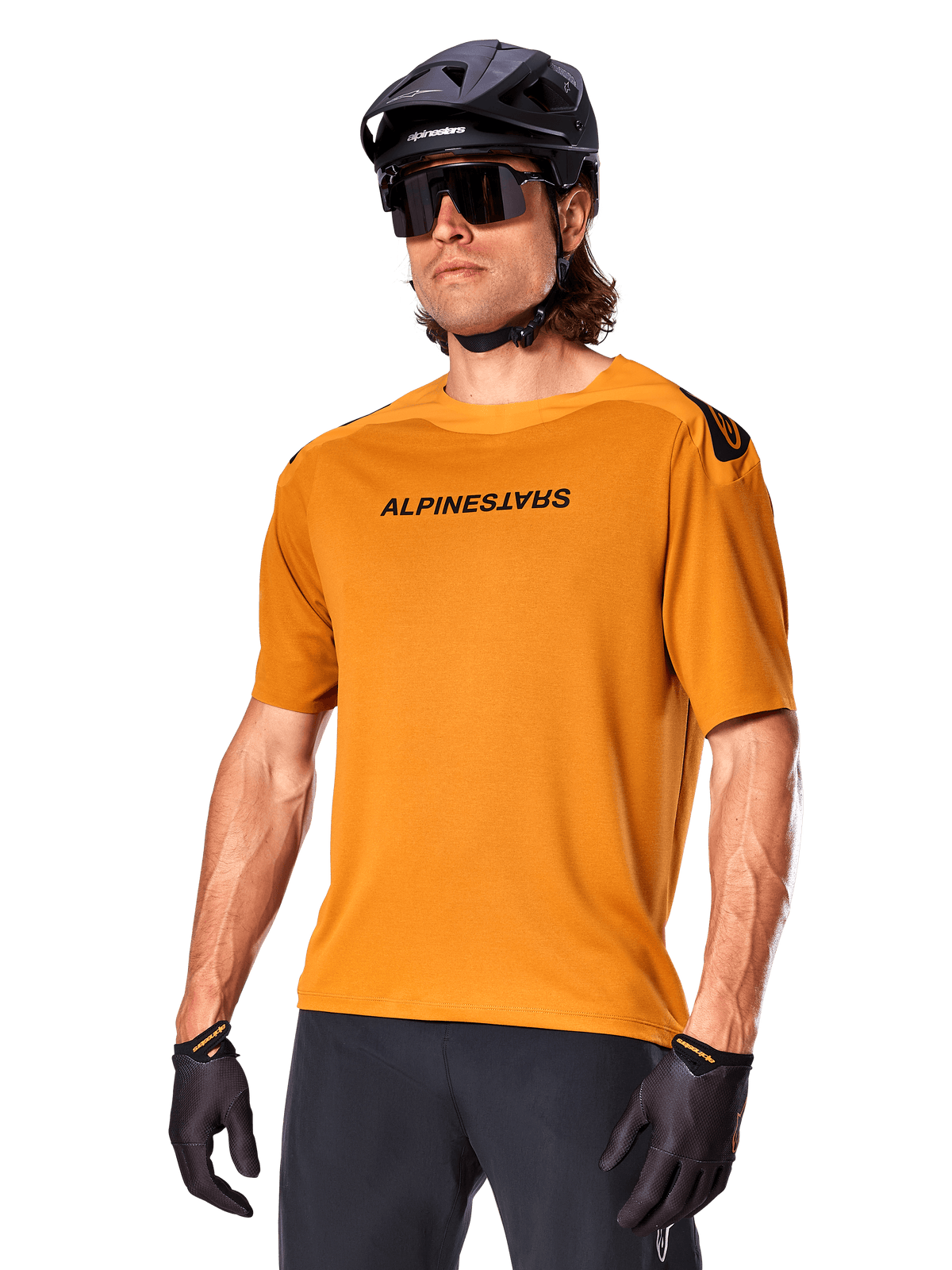 Alpinestars A-Aria Polartec Switch Jersey, Short Sleeve MTB Jersey, Dark Gold with black branding, worn by model with black helmet, sunglasses, and cycling gloves, high-performance mountain bike apparel