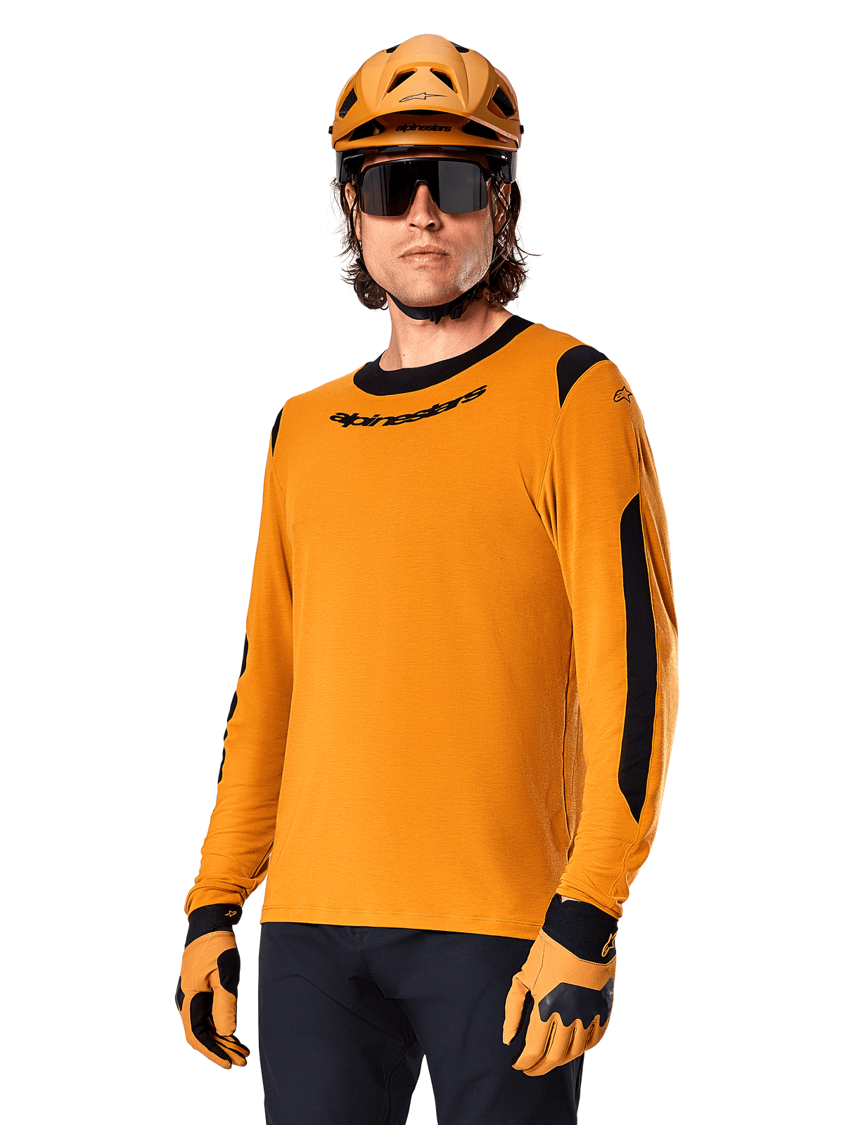 Alpinestars A-Dura Dri Wool Jersey met lange mouwen, MTB mountainbike-shirt, donkergoud en zwart, voorzien van een vochtafvoerende merinowolmix en mesh-panelen, fietser met bijpassende helm, zonnebril en handschoenen