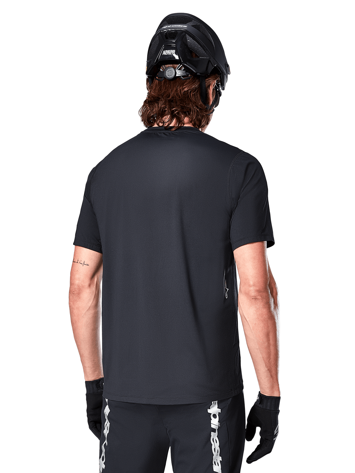 Alpinestars A-Dura Switch Jersey, zwarte heren MTB-jersey met korte mouwen, achteraanzicht met verlengd achterpand op model.