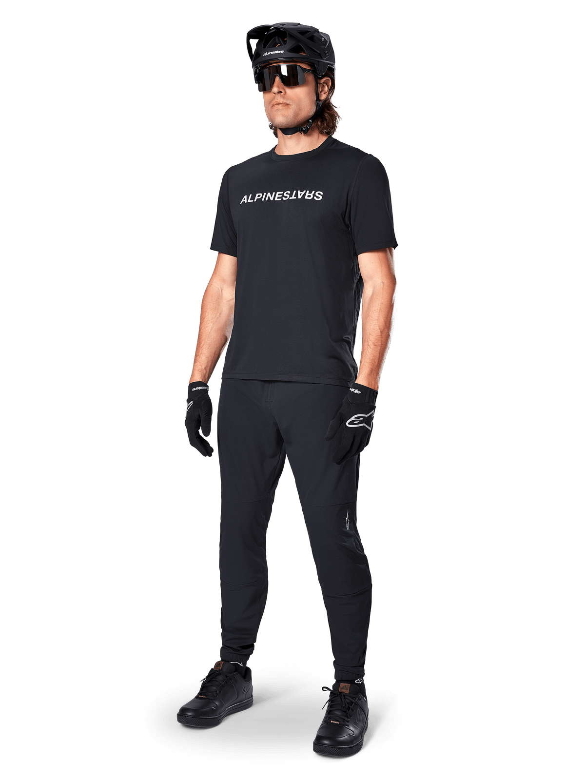 Alpinestars A-Dura Switch jersey, zwart MTB-shirt met korte mouwen en wit borstlogo, gedragen door een mannelijke fietser.