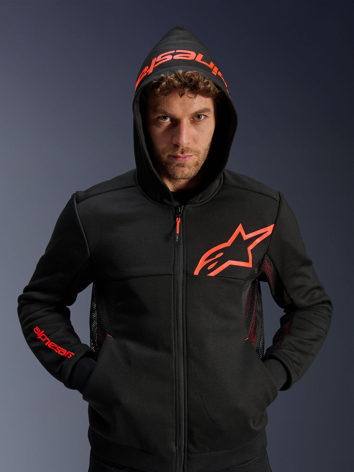Alpinestars Chrome Air Sport Hoodie, zwart en neonrood, urban motorhoodie met mesh ventilatiepanelen, rood Astar-logo op de borst en merknaam op de capuchon, casual motorkleding voor stedelijke omgevingen.