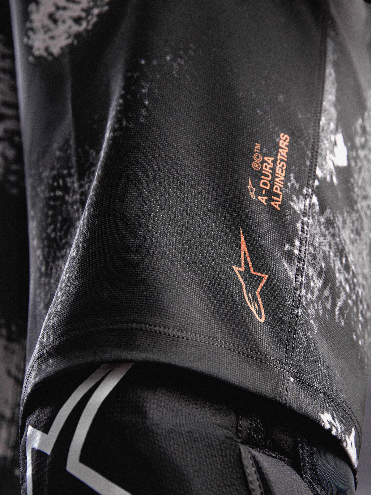 A-Dura Ride shorts in Black Camo met oranje Alpinestars-logo op duurzame 4-way stretch geweven stof voor MTB.