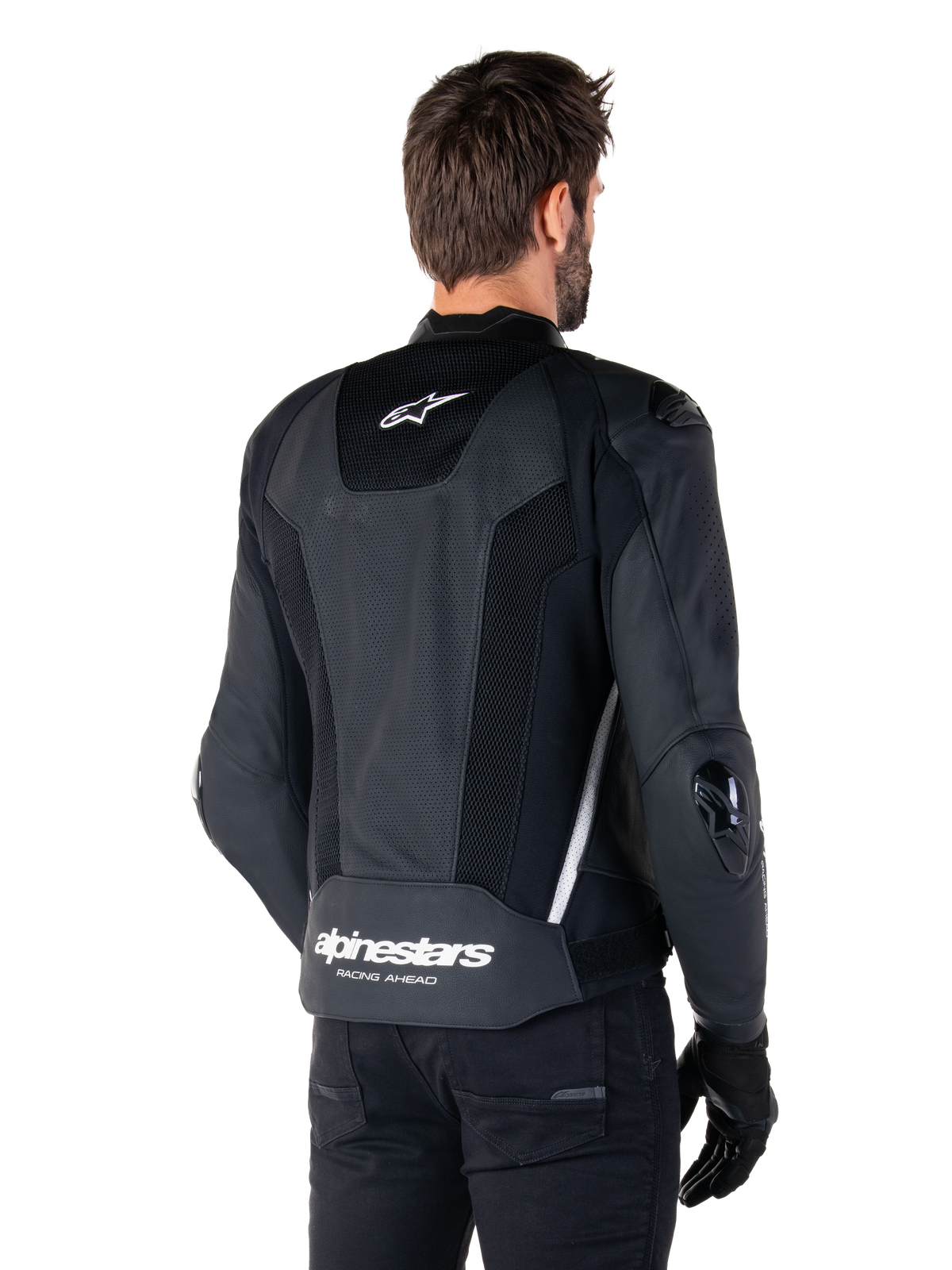 Alpinestars Missile V3 Airflow Leren Jas, zwart en wit, achteraanzicht met geperforeerd leer en mesh-panelen voor maximale ventilatie, witte Alpinestars-branding op de onderrug en sterlogo in de nek, gedragen met zwarte rijuitrusting, premium racing sportontwerp