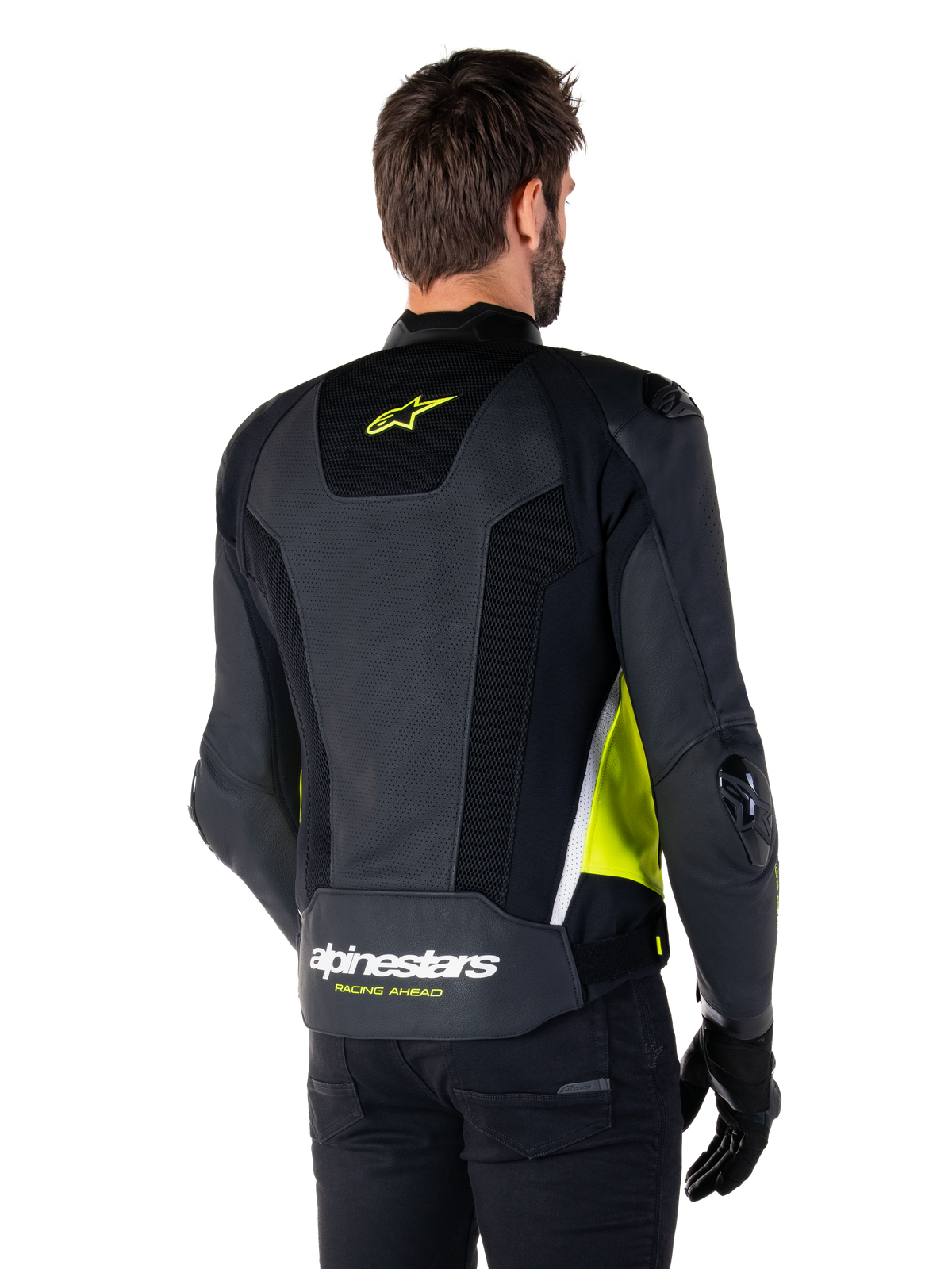 Alpinestars Missile V3 Airflow Leren Jas, achteraanzicht op een mannelijk model, zwart met fluo gele en witte accenten, voorzien van uitgebreide geperforeerde leren en mesh panelen op de rug, met een geel sterlogo en witte 'RACING AHEAD' tekst, gecombineerd met zwarte handschoenen en broek.