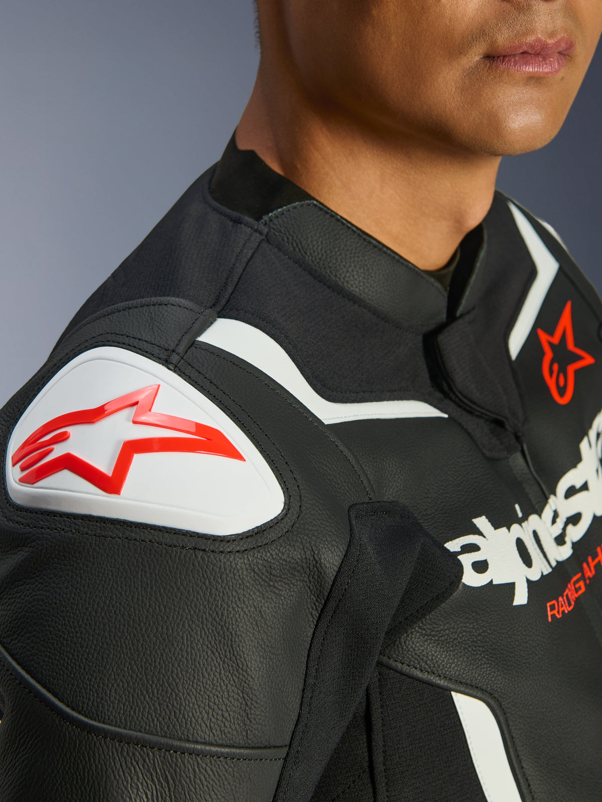 Alpinestars GP Force V2 Leren Jas, zwart en wit, close-up van GP Lite Evo DFS-schouderbeschermer met rood Alpinestars-logo, meerlaagse constructie van premium rundleer, geïntegreerde stretchpanelen voor sportief rijden