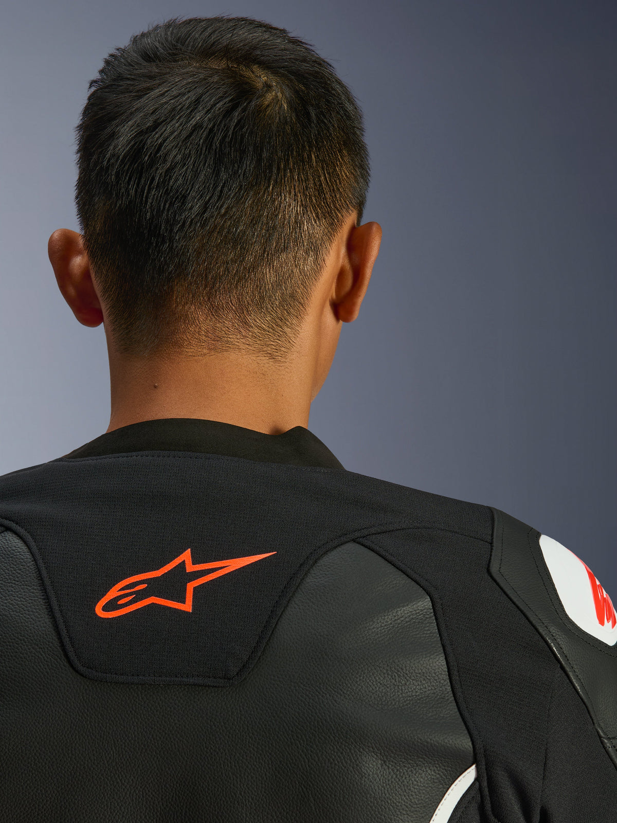 Alpinestars GP Force V2 Leren Jas, zwart en wit, close-up achteraanzicht van de nek en schouders, rood Alpinestars-logo, premium leer met textiel stretchpanelen, sportief performance-ontwerp