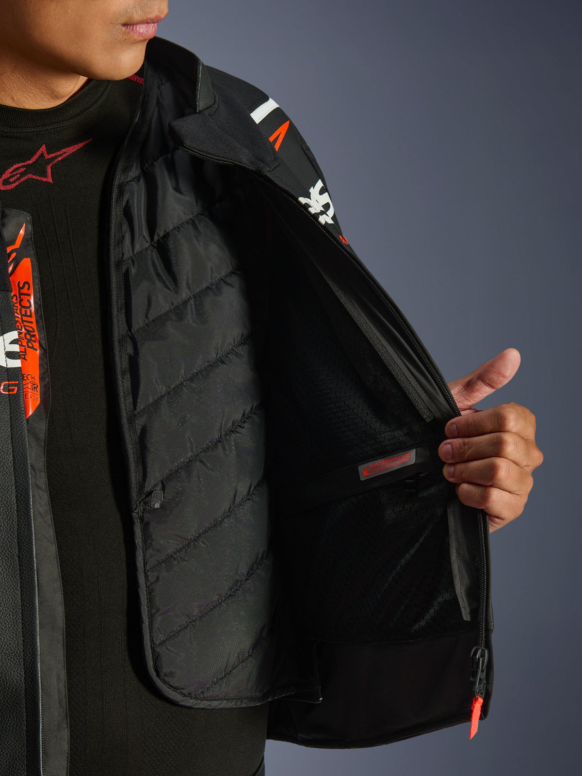 Alpinestars GP Force V2 Leren Jas, zwart en wit, detailweergave van de binnenkant met de uitneembare gewatteerde thermische voering en waterdichte binnenzak, gedragen over een zwarte basislaag, hoogwaardige motorkleding