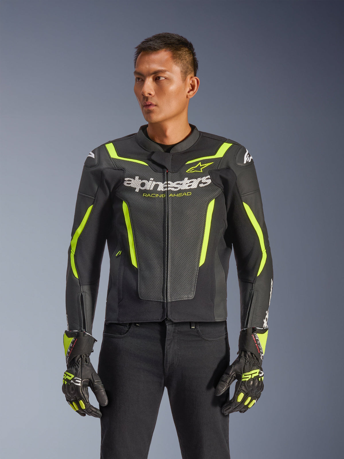 Alpinestars GP Force V2 Air Leather Jacket, Black and Yellow Fluo, perforated leather motorcycle jacket with protective armor and neon accents, worn with matching racing gloves and black pants, athletic sport fit with bold branding