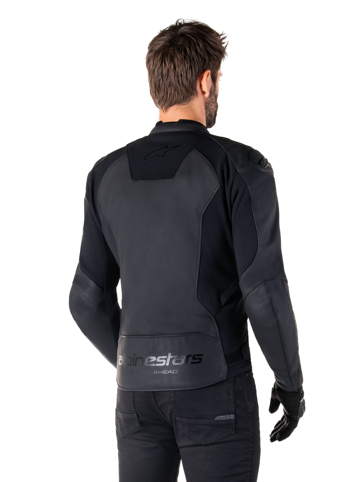 Alpinestars Faster V3 Leren Jas, Zwart, achteraanzicht van model dat de sportieve motorjas draagt, met 'alpinestars' en 'RACING AHEAD' logo's op de onderrug, premium leer met matte panelen, modern sportief silhouet voor motorrijden