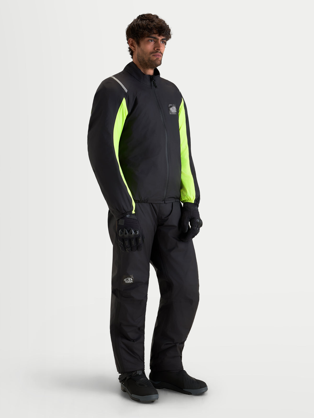Alpinestars Harok V 2 Drystar jas, heren avontuur motorjas in zwart en fluorgeel, gedragen met bijpassende motoruitrusting op een on-model productfoto