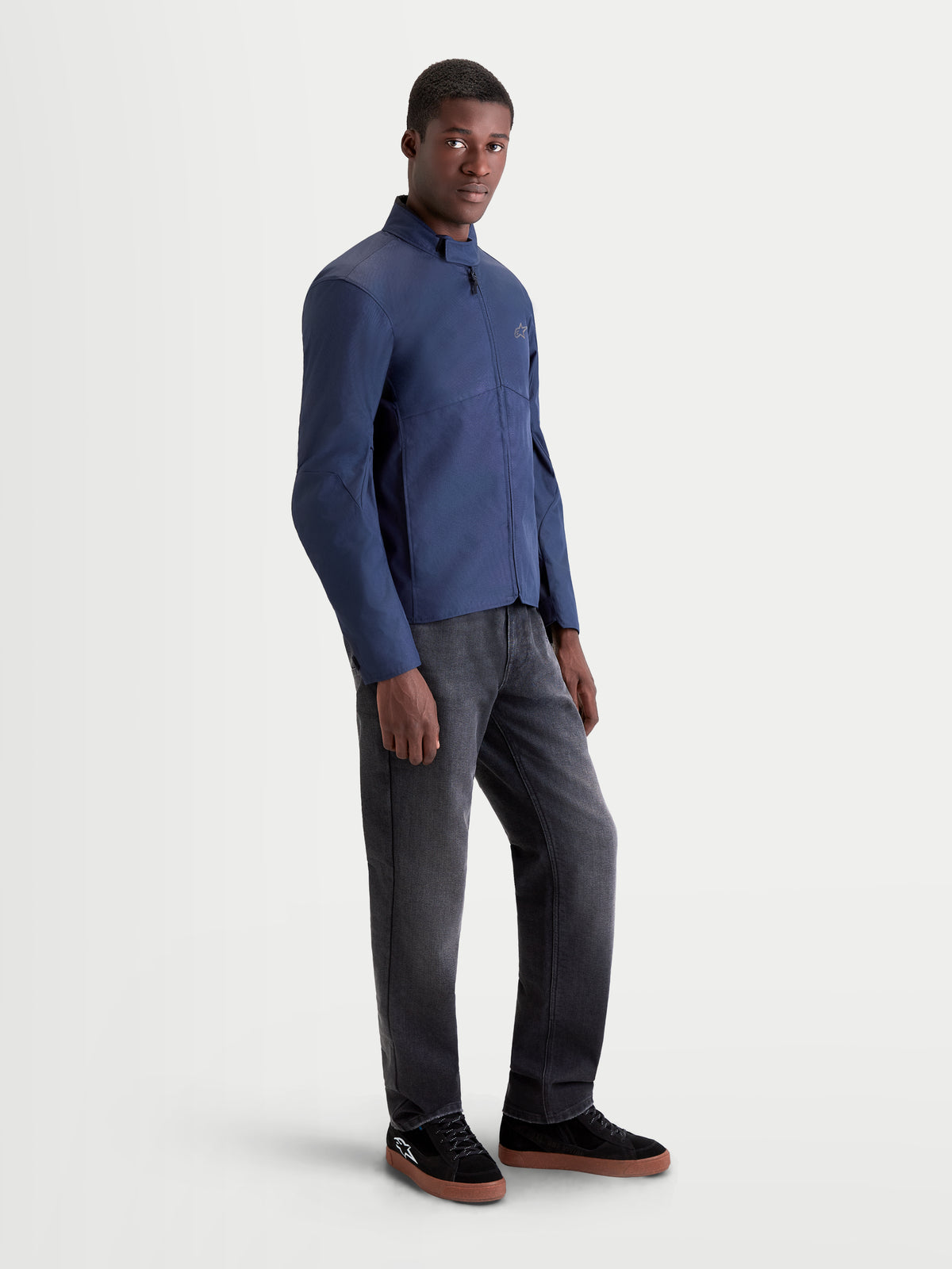 Alpinestars C-1 Waterproof Jas, heren urban motorjas in donkerblauw, zijprofiel op model met donkere broek en casual motorlaarzen
