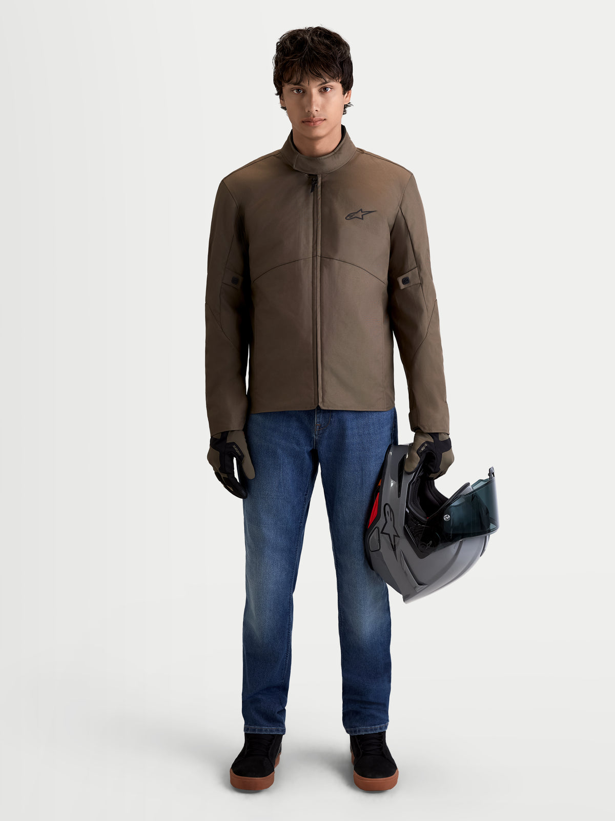 Alpinestars C-1 Waterproof Jas, stedelijke moderne motorjas van textiel voor heren in walnootbruin en zwart, vooraanzicht op model met de jas en een helm