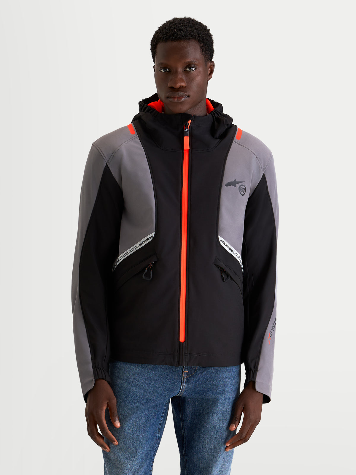 Alpinestars C-5 Drystar jas, heren urban contemporary motorjas in zwart en donkergrijs, vooraanzicht op een model met waterdichte softshell constructie, geïntegreerde capuchon en helderoranje ritsdetails