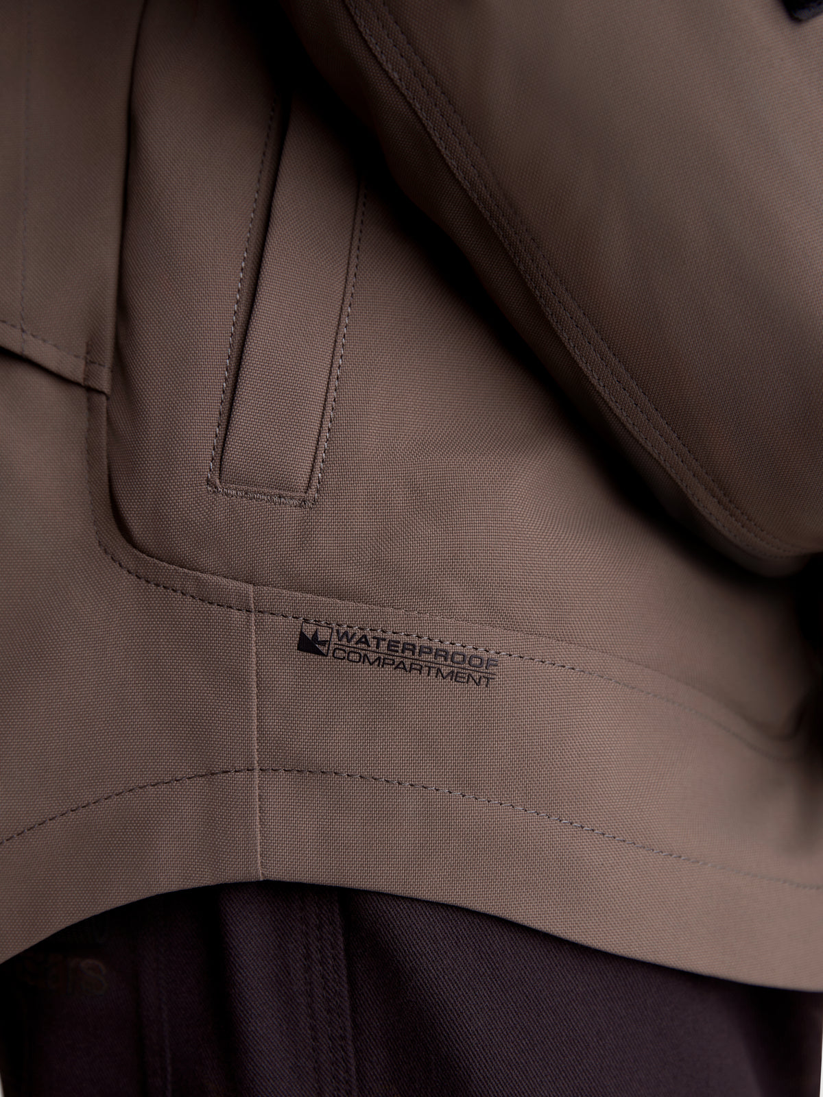 Alpinestars Altan Drystar jas, detailopname van het walnootbruine waterdichte vak en de zakconstructie op de matte textiel motorjas