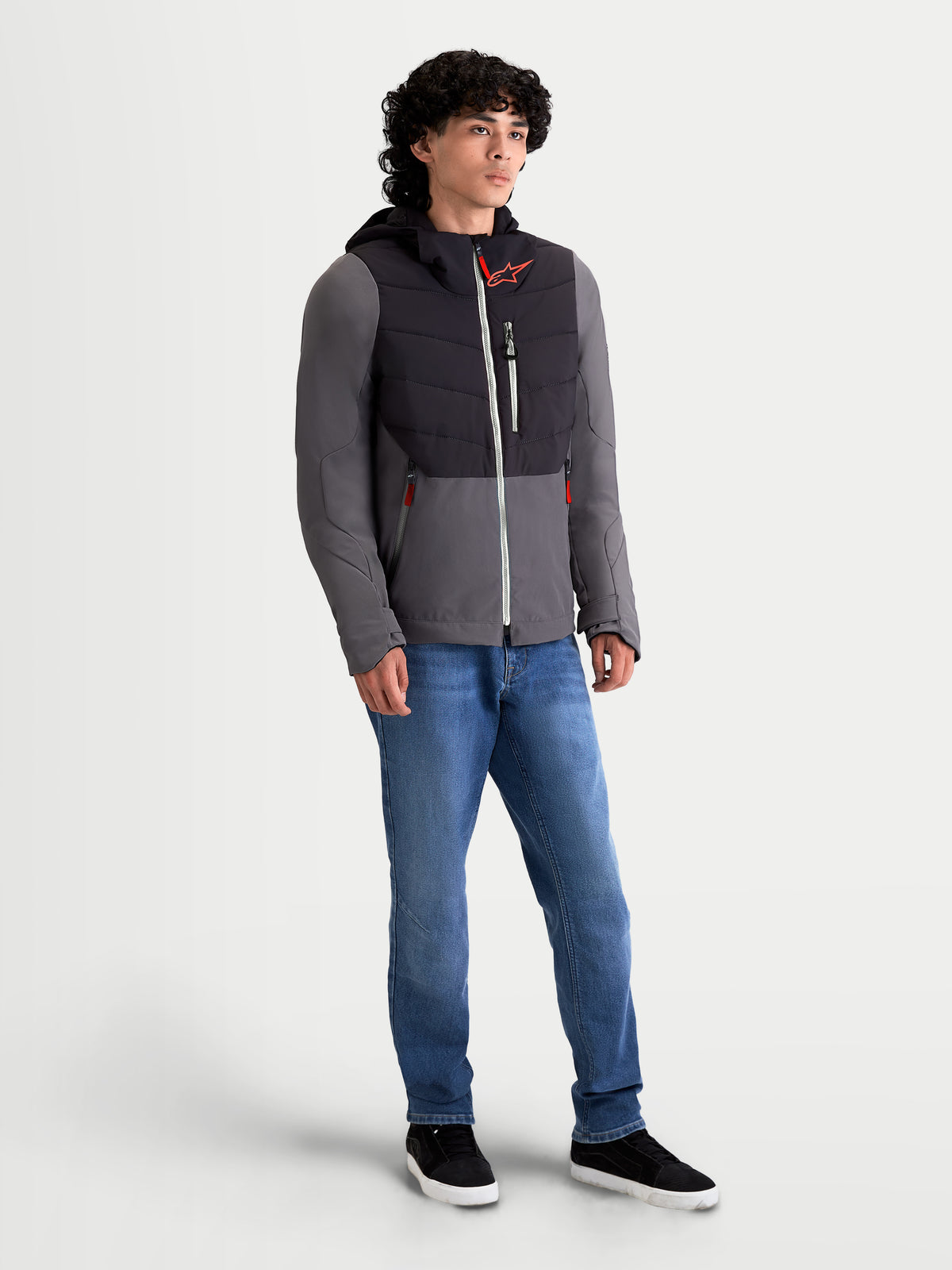 Alpinestars Therma-Tech Waterdichte Jas, heren urban contemporary motorjas in zwart en donkergrijs, driekwart vooraanzicht gedragen door een model met een geïntegreerd capuchonsysteem