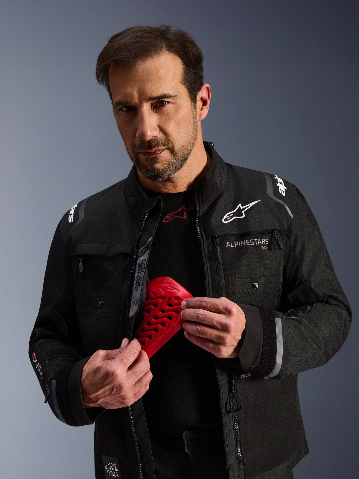 Alpinestars Cusco Drystar® jas, zwarte adventure-touring motorjas voor heren met een rood Nucleon Flex Pro beschermstuk.