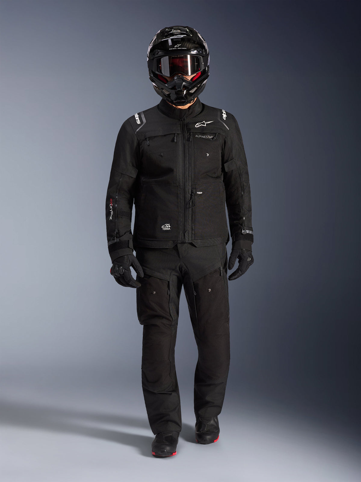 Alpinestars Cusco Drystar® jas, zwarte heren adventure touring motorjas van ripstop, gedragen met bijpassende broek en helm.