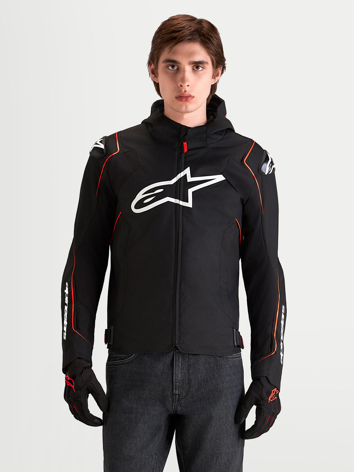 Alpinestars Zaca V 2 Waterproof Jas, heren motorjas voor sportriding, zwart en rood fluo, voorzien van DFS-schouderbescherming en een wit Astar-logo op de borst, gedragen door een model in een studiofotoreportage