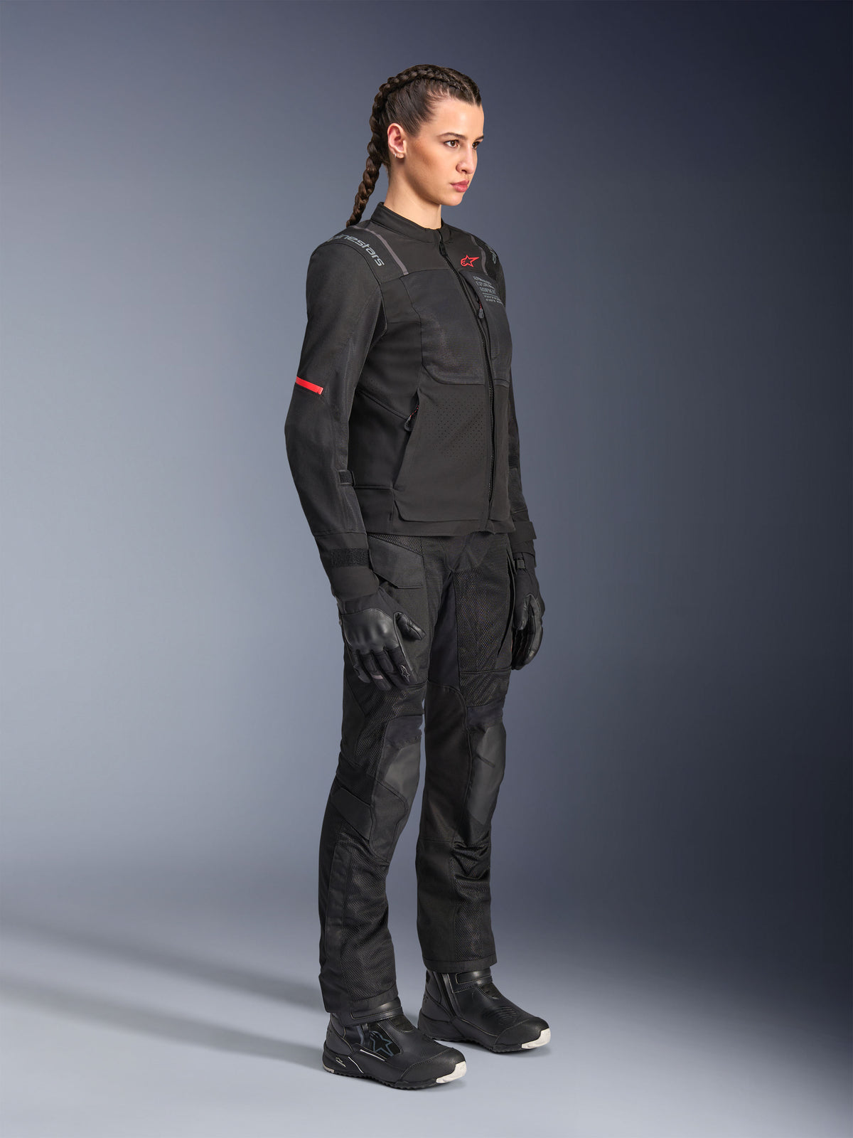 Vrouwelijke rijder draagt Alpinestars Stella Andes Air Drystar® broek in het zwart, textielen adventure broek met mesh ventilatiepanelen, gestyled met een bijpassende Stella jas, handschoenen en laarzen voor een complete motor touring outfit.