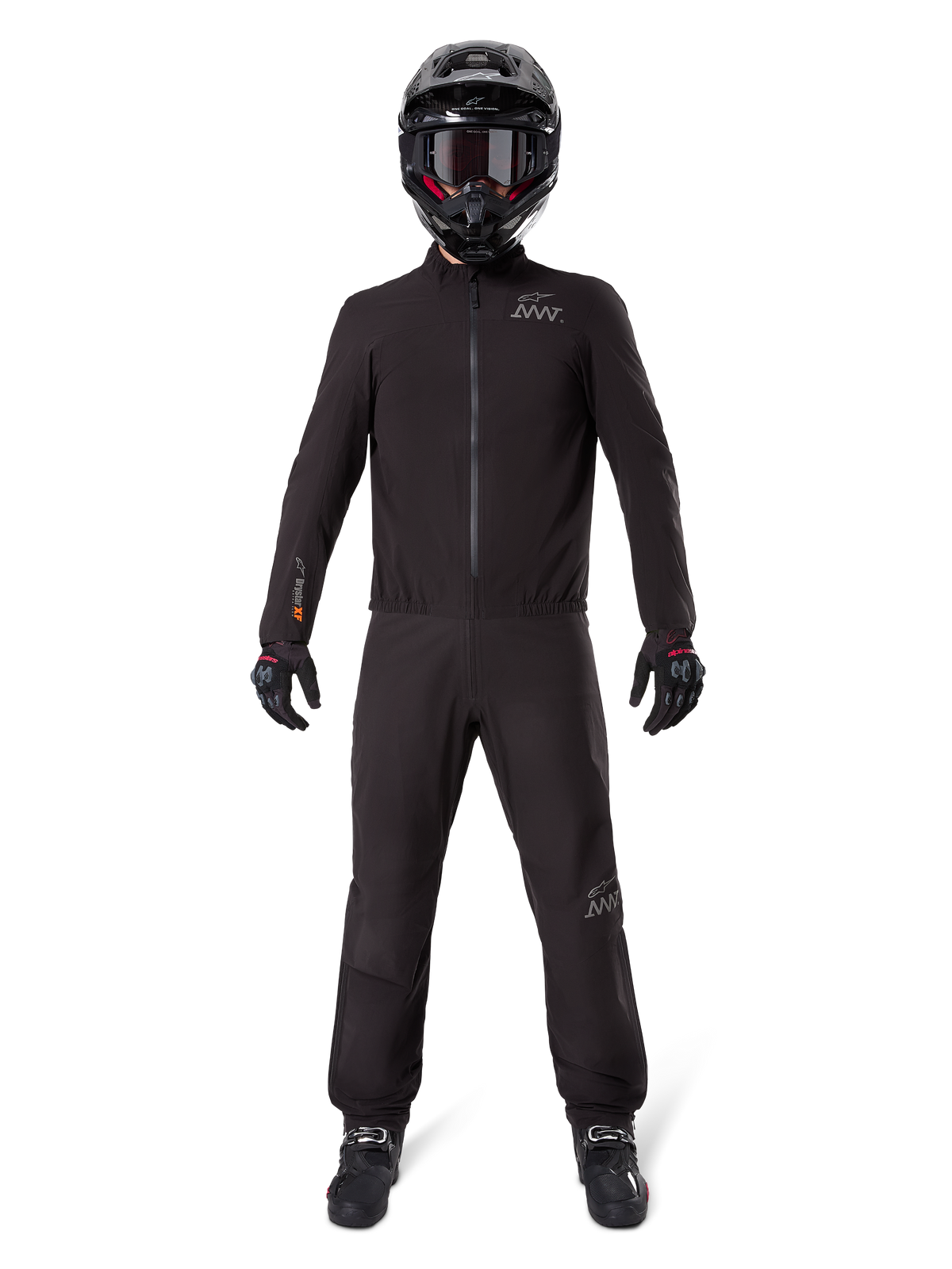 Motorrijder in Alpinestars AMT-8 Stretch Drystar® XF broekvoering en bijpassende jas, volledig zwarte waterdichte en winddichte technische uitrusting, met een zwarte helm, handschoenen en laarzen, strak adventure touring ontwerp.