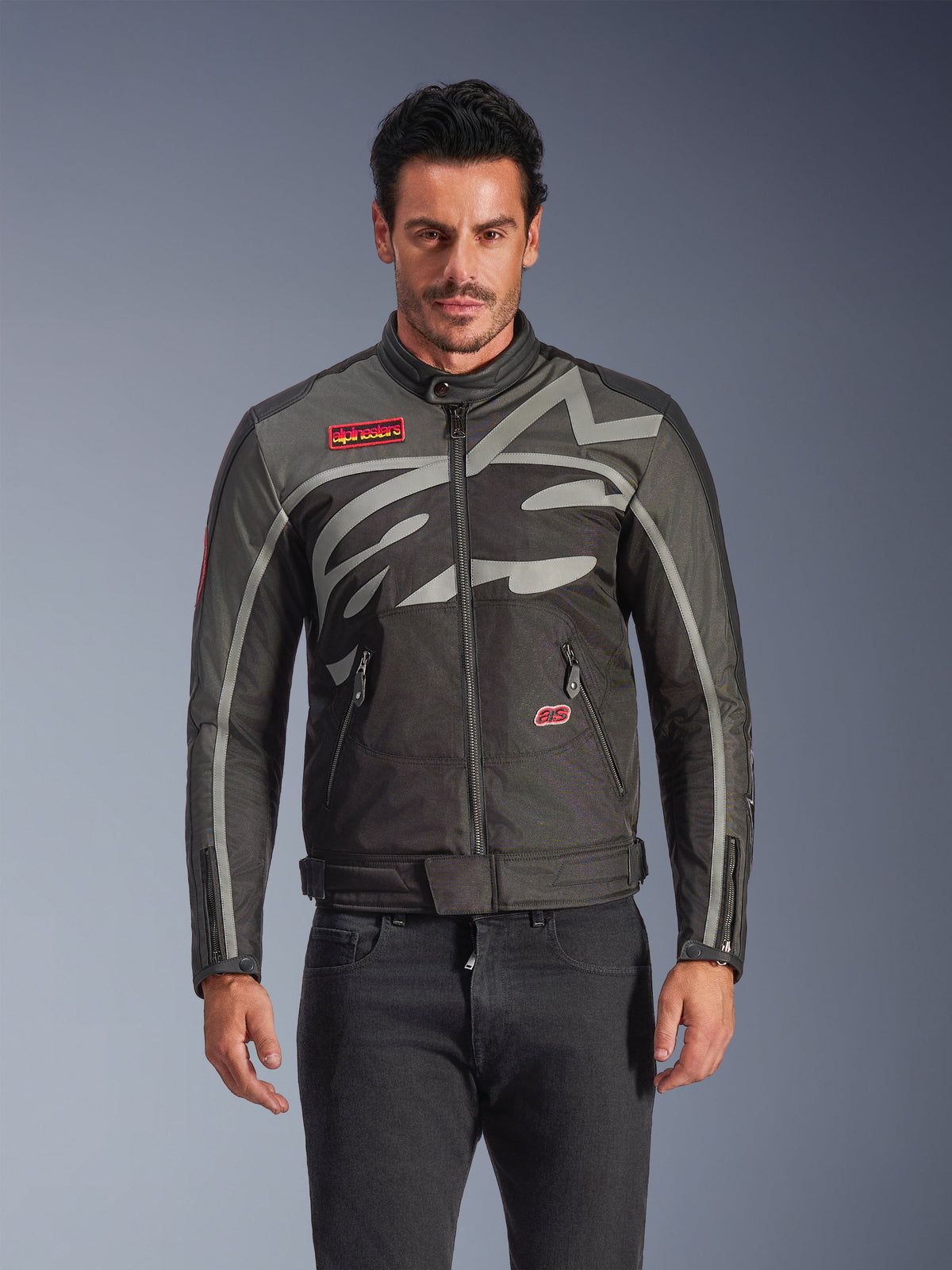Alpinestars Axton motorjas, urban motorjas voor heren, zwart en antraciet met rode accenten, met een grote rondomlopende lichtgrijze grafische print, rode logo-patches op de borst en zak, ritssluiting aan de voorzijde en ritsen bij de manchetten, vintage-geïnspireerd race-ontwerp voor op de weg