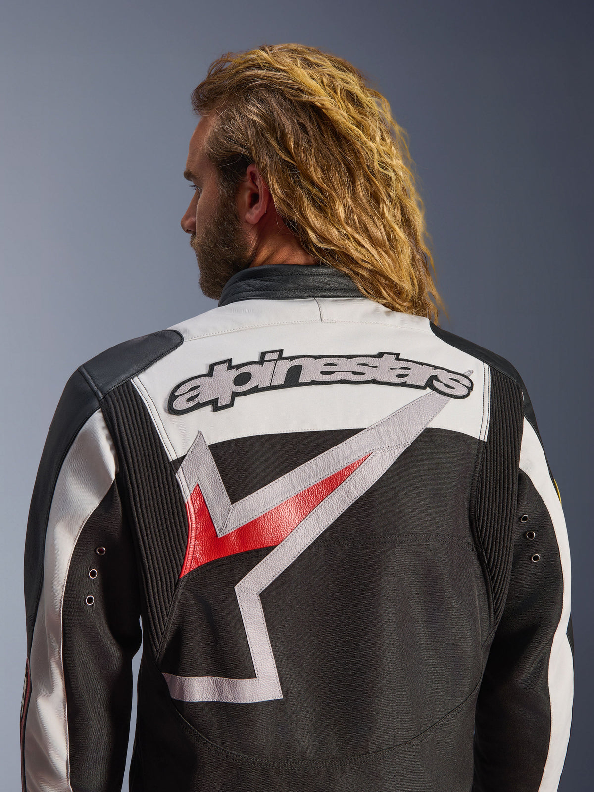 Alpinestars Axton Jas, motorjas, zwart, gebroken wit en felrood, achteraanzicht met groot geborduurd Alpinestars-logo en gestileerde graphic, accordeon schouderpanelen voor bewegingsvrijheid, vintage-geïnspireerd ontwerp met metalen oogjes