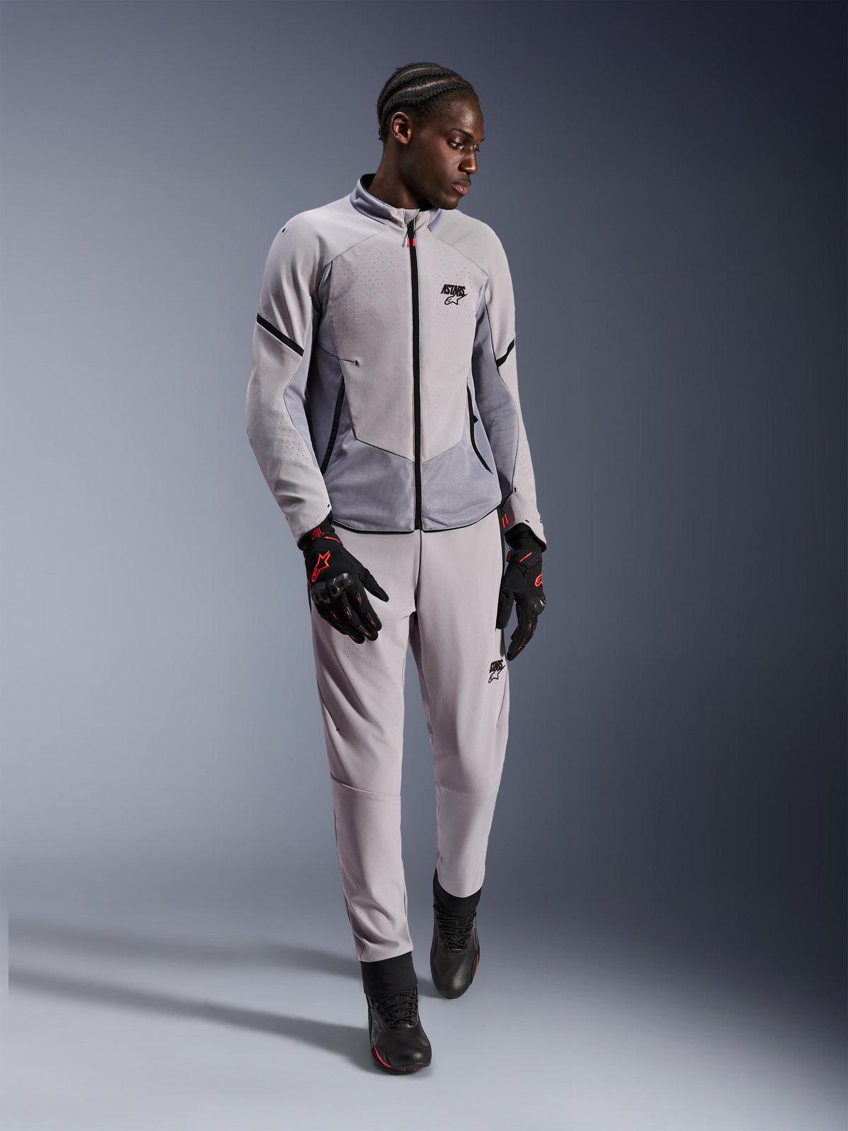 Alpinestars Aeroshell Airflow Jacket, Mid Gray Anthracite, textiele motorjas met laserperforaties en meshpanelen, gedragen met bijpassende broek en zwarte rijaccessoires, lichtgewicht en sportief ontwerp voor prestaties bij warm weer