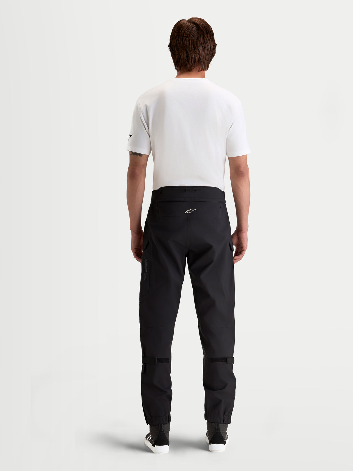 Alpinestars Juggernaut V2 Drystar broek, waterdichte urban motorbroek voor heren in zwart, achteraanzicht met hoge tailleband en technische textielconstructie gedragen door een model