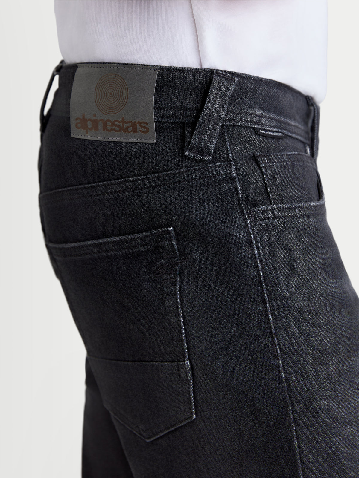Alpinestars Flex Ast 8 Denim broek, urban motorjeans in gebruikt zwart, detailweergave van de leren rugpatch en achterzakken op een model