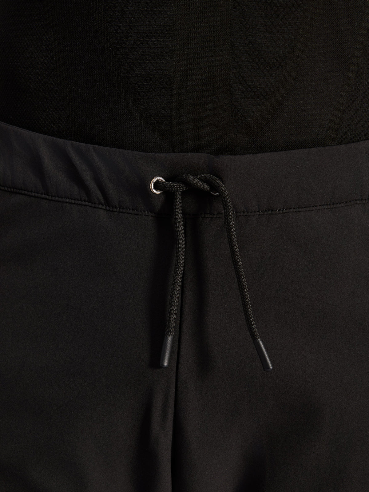 Alpinestars Aeroshell Airflow broek, zwart, close-up van de tailleband met verstelbaar intern elastisch trekkoord en zilverkleurig oogje, sport-touring motoruitrusting