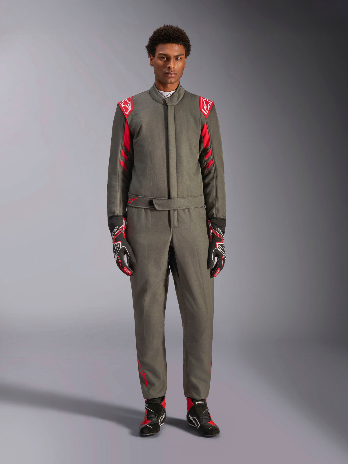 Alpinestars GP Race V3 Suit FIA, Auto Racing Suit, Anthracite Red, worn by a male model with matching gloves and boots, featuring red shoulder epaulettes and branding, professional motorsport gear for performance driving.