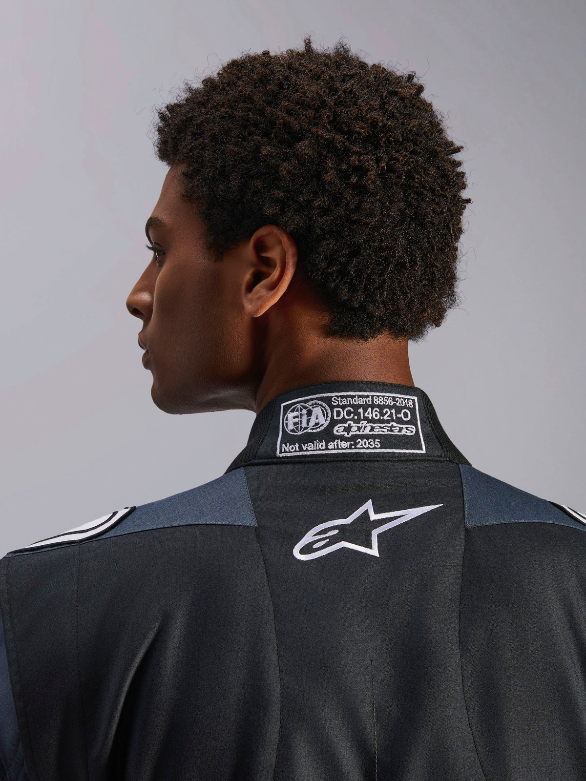 Alpinestars GP Pro Comp V2 FIA heren-autoracepak, zwart en asfalt, FIA 8856-2018 certificering en wit Astar-logo.