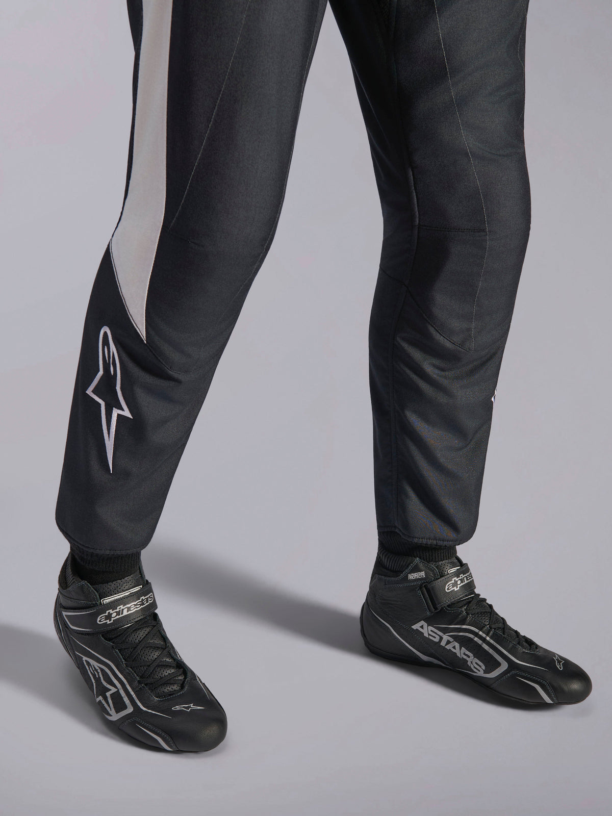 Alpinestars GP Pro Comp V2 FIA-pak, zwart en wit autoracepak met bijpassende professionele ASTARS-raceschoenen.