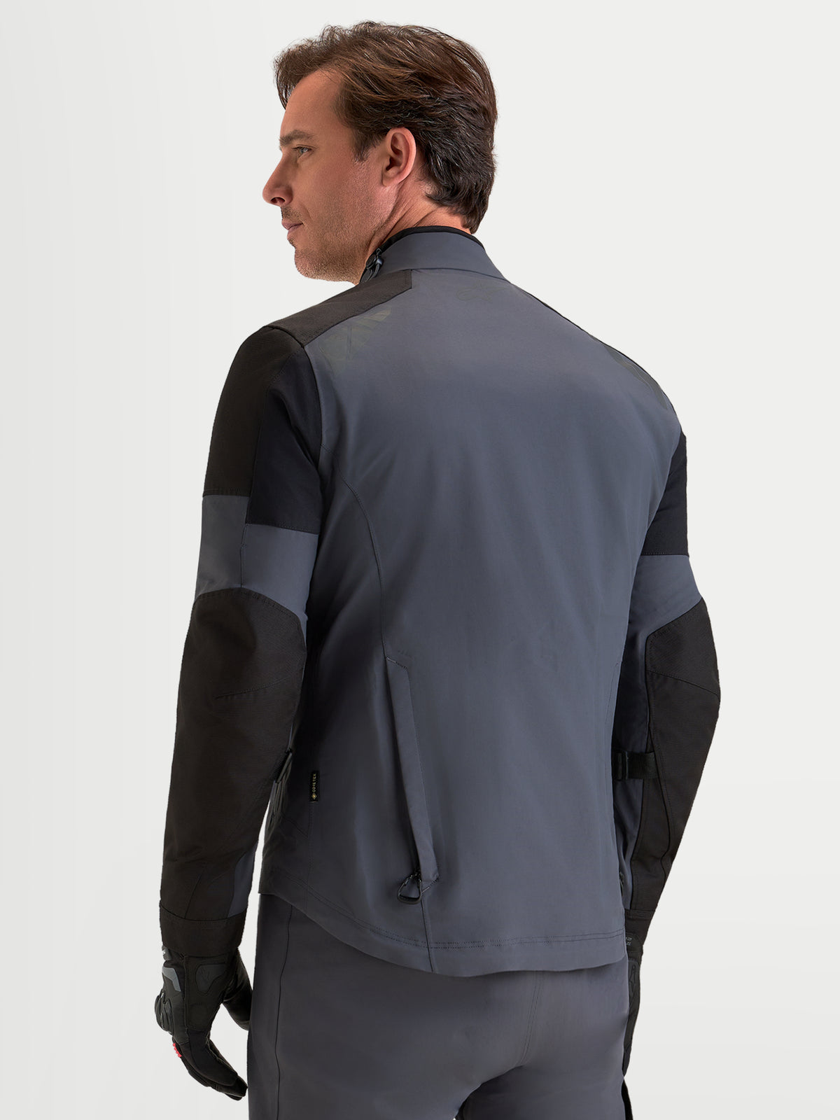 Alpinestars Arenis Gore-Tex jas, heren adventure motorjas in zwart en donkergrijs, achteraanzicht met waterdichte textielconstructie en ergonomische kraag op model