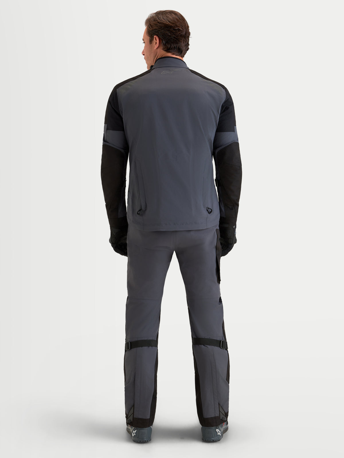 Alpinestars Arenis Gore-Tex jas, adventure motorjas voor heren in zwart en donkergrijs, achteraanzicht op model met waterdichte textielconstructie en geïntegreerde ventilatieopeningen aan de achterzijde