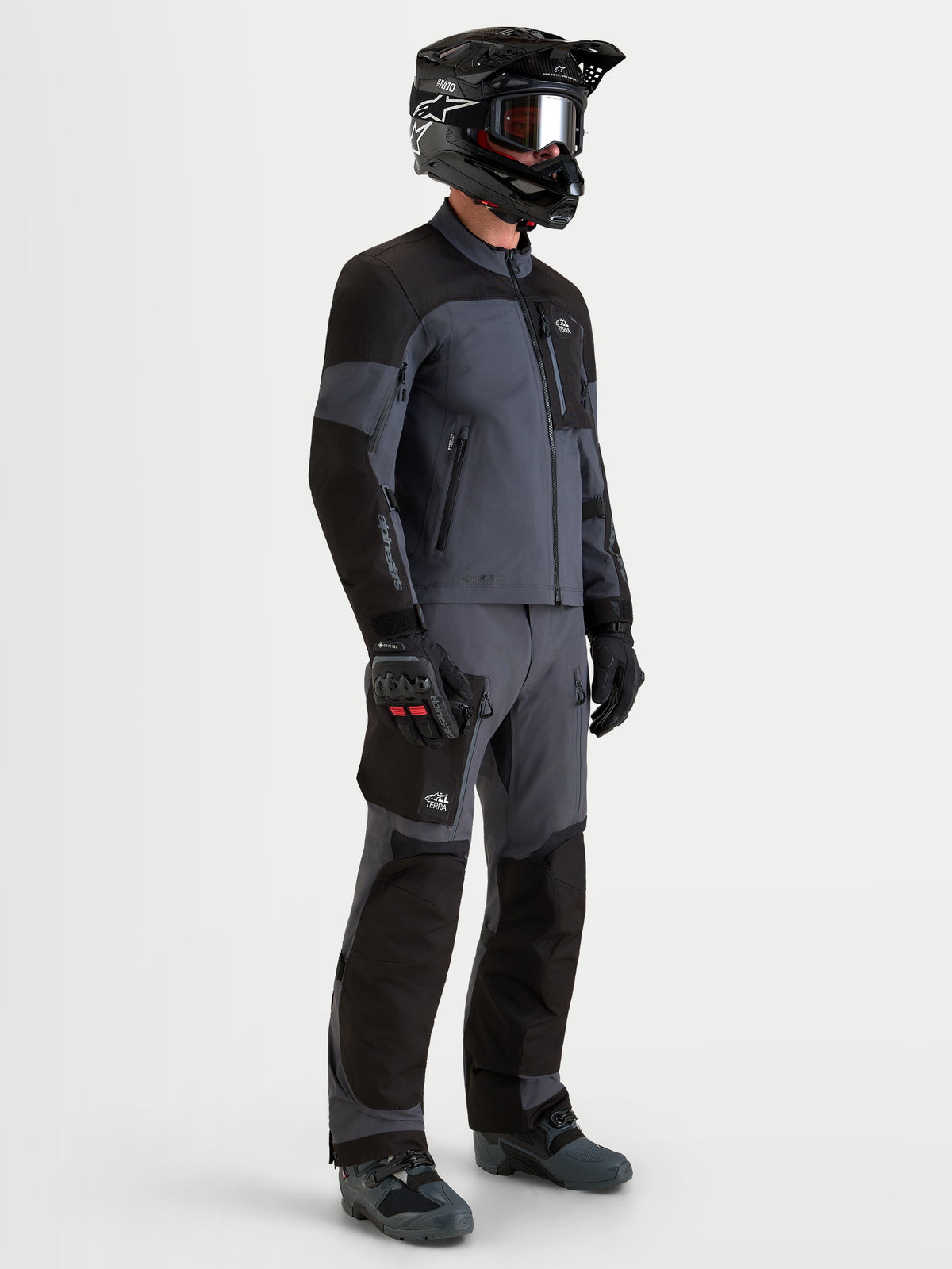 Alpinestars Arenis Gore-Tex jas, heren all-terrain adventure-motorjas in zwart en donkergrijs, zijaanzicht met waterdichte textielconstructie en ergonomische kraag op model