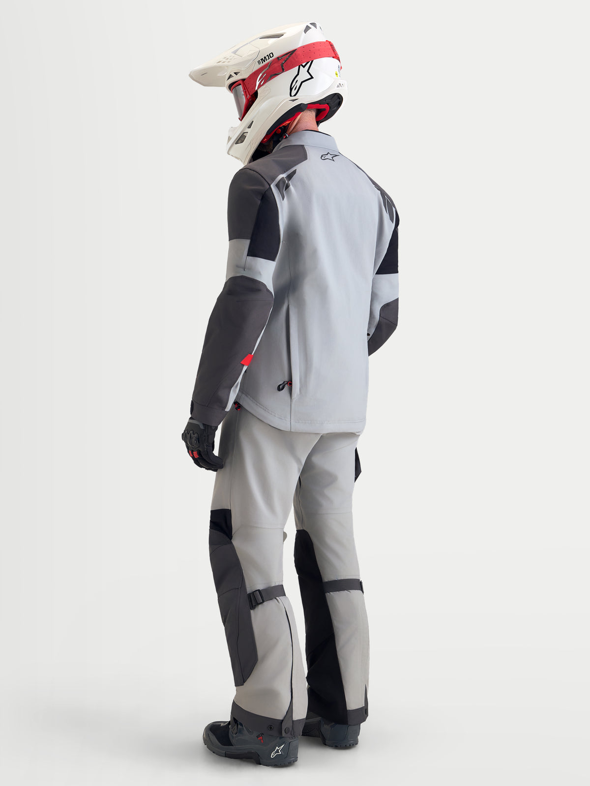 Alpinestars Arenis Gore-Tex uitrustingsset, adventure motorjas en broek voor heren in lichtgrijs en zwart, achteraanzicht op een model met bijpassende uitrusting en helm, waterdichte textielconstructie