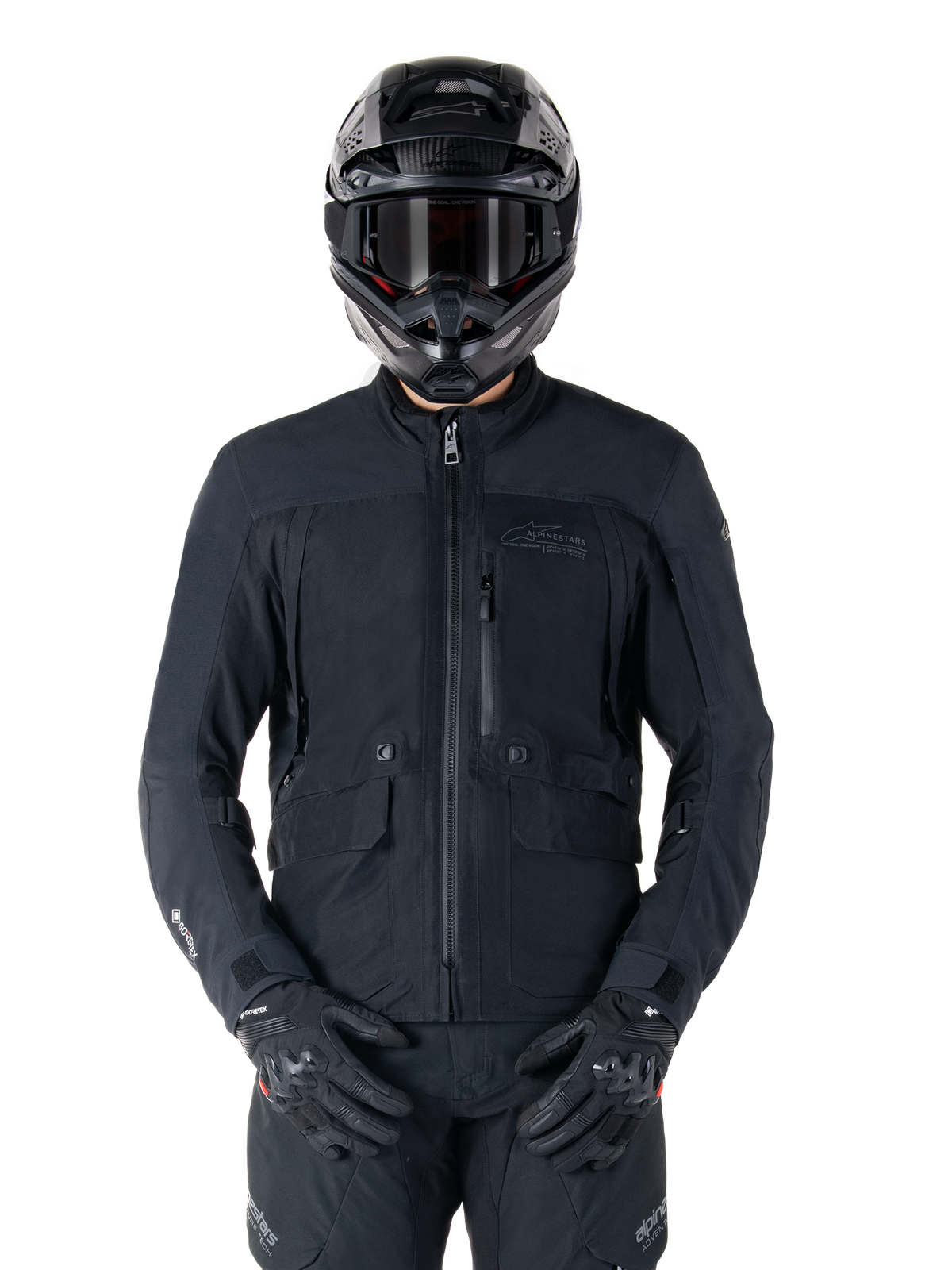 Alpinestars St-7 Prime GORE-TEX jas, zwarte motor touringjas, waterdicht en ademend, ritssluiting aan de voorzijde, meerdere zakken, gedragen met bijpassende helm en handschoenen, premium bescherming voor rijden in alle weersomstandigheden