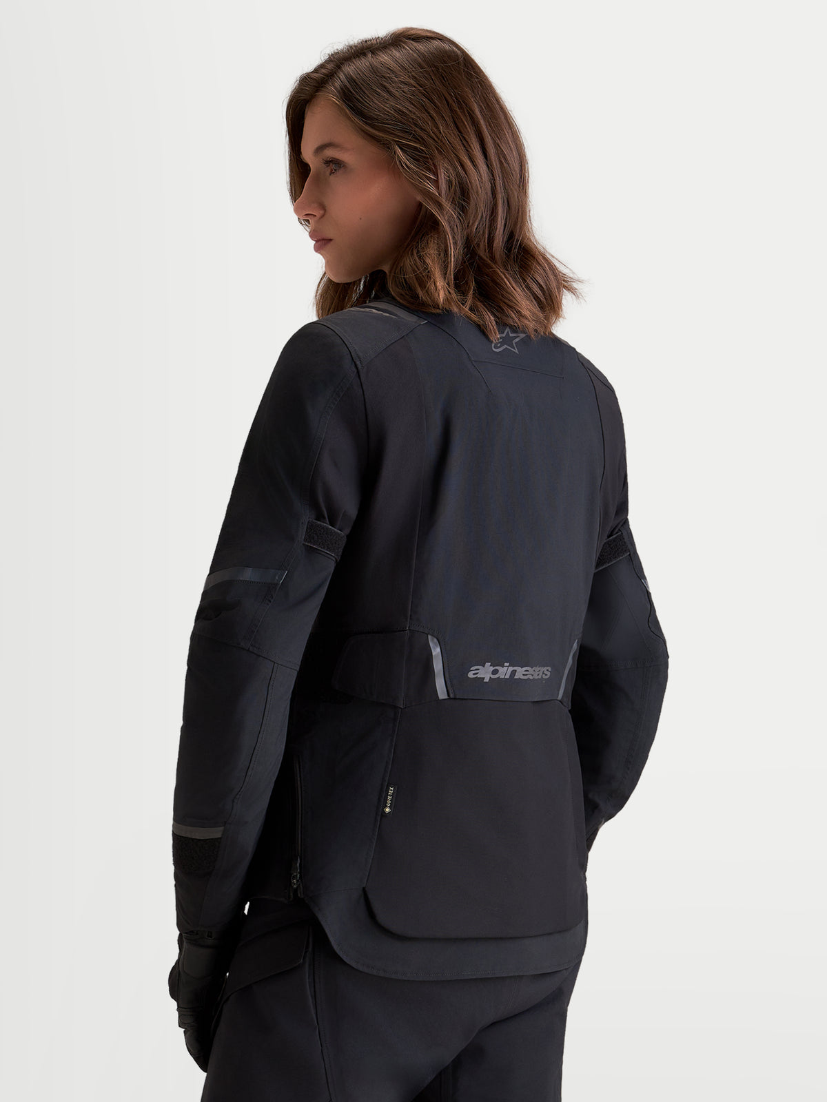 Alpinestars Stella ST-7 V2 2L GORE-TEX jas, dames adventure motorjas in het zwart, achteraanzicht op een model met waterdichte textielconstructie en reflecterende brandingdetails
