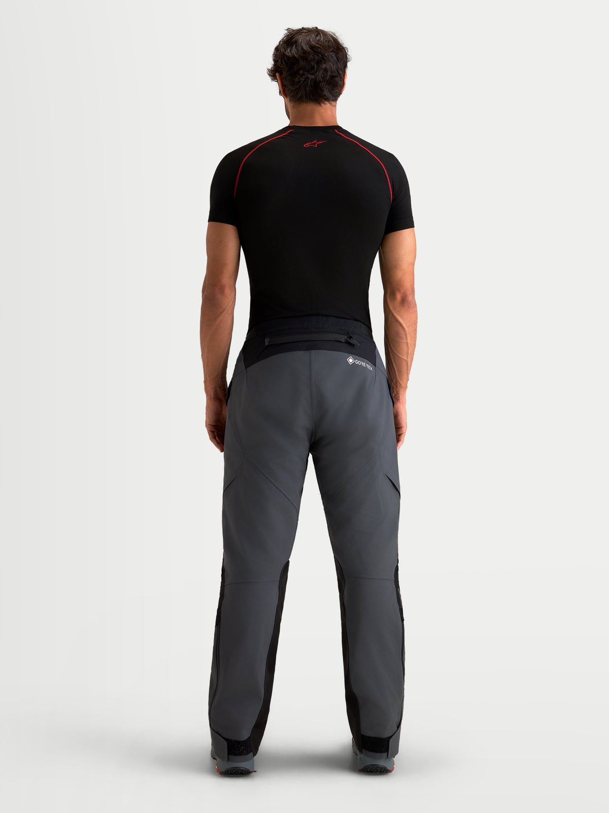 Alpinestars St-7 V2 2L Gore-Tex® Pants, men's adventure touring motorcycle pants in deep gray and black, rear view on a model wearing the waterproof textile pants with GORE-TEX and reinforced seat construction.