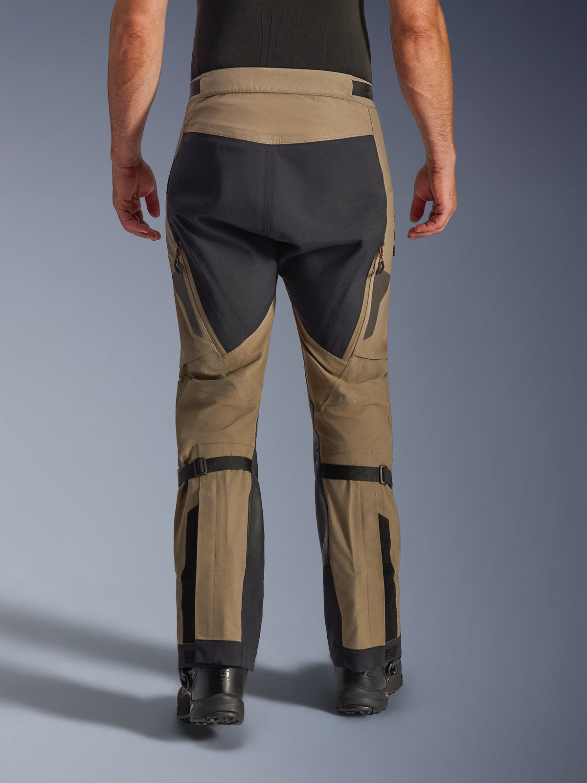Alpinestars Nazca 3L GORE-TEX PRO-broek, Walnut en Black, achteraanzicht met kuitvolumeregelaars en versterkte panelen, technische adventure motorbroek voor rijden in alle weersomstandigheden