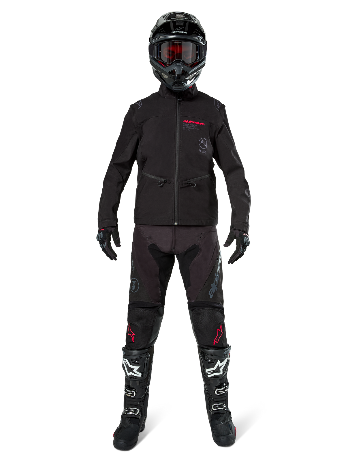 Motocross rider wearing the Alpinestars Lite-Dura Softshell Jacket in Black with red logo details, styled with matching black off-road pants, black helmet, and white and black boots, complete professional enduro racing gear.