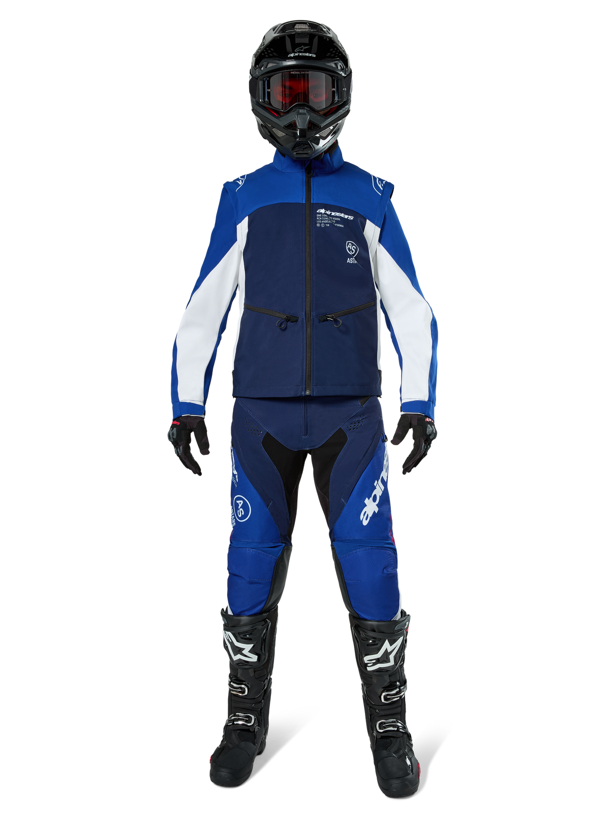 Alpinestars Lite-Dura Softshell Jas, off-road motorjas in navyblauw, helderblauw en wit, gedragen met een bijpassende volledige uitrusting inclusief zwarte helm, endurobroek en zwarte laarzen, technische winddichte kleding voor dirtbike-rijden