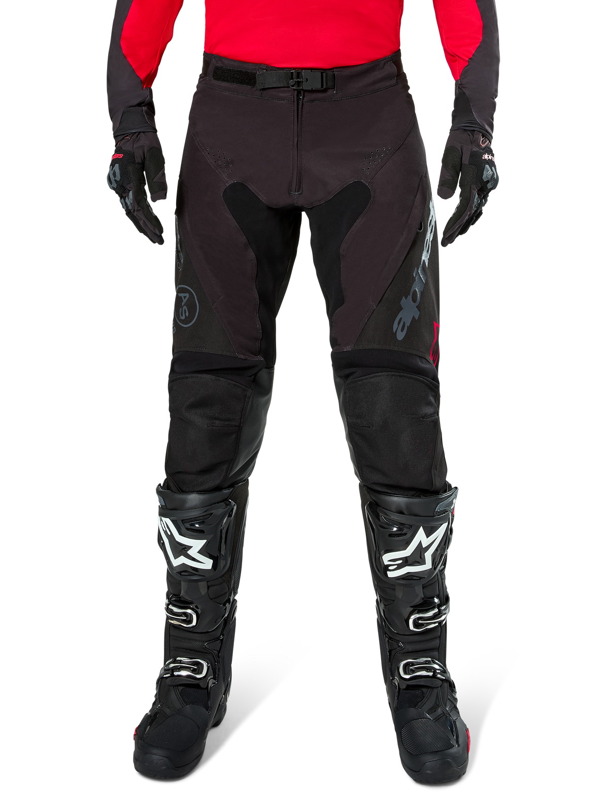 Alpinestars Pro-Dura Pants, zwarte en magnet endurobroek, gedragen met een rode jersey met lange mouwen en zwarte motorcrosslaarzen, voorzien van grijze Alpinestars-branding en een duurzame ripstop-constructie voor off-road rijden
