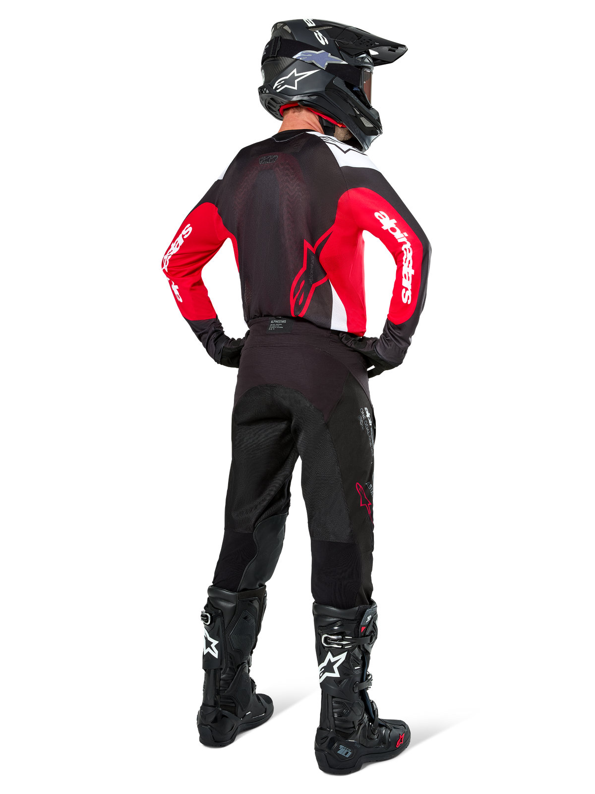 Motorcrossrijder van achteren gezien die Alpinestars Pro-Dura Pants in Black Magnet White draagt, gecombineerd met een rood en zwart jersey en zwarte laarzen, gecoördineerde off-road uitrusting voor enduro rijden