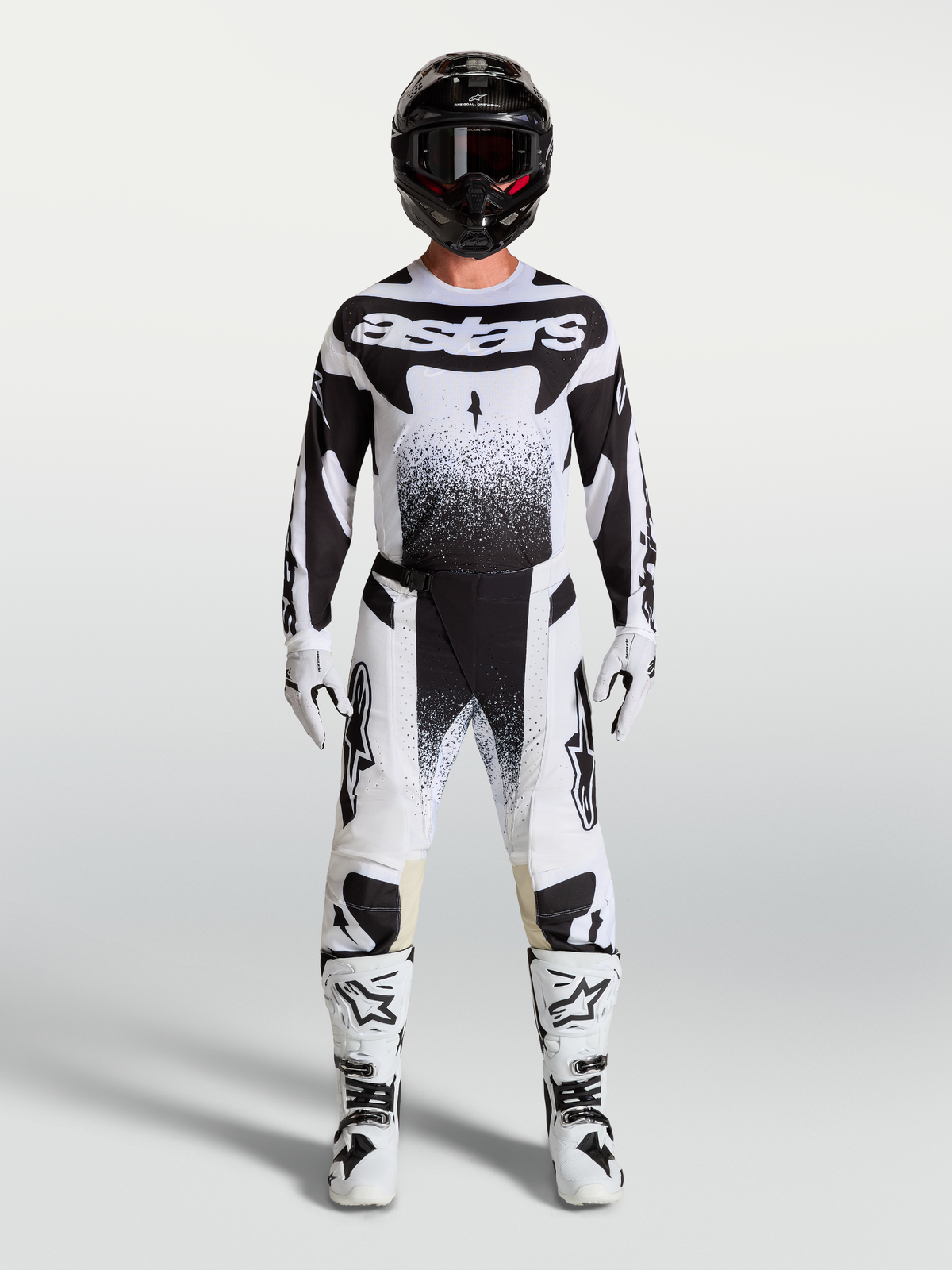 Alpinestars Techstar Swan broek en jersey, wit en zwarte motocross-set gedragen door een model.