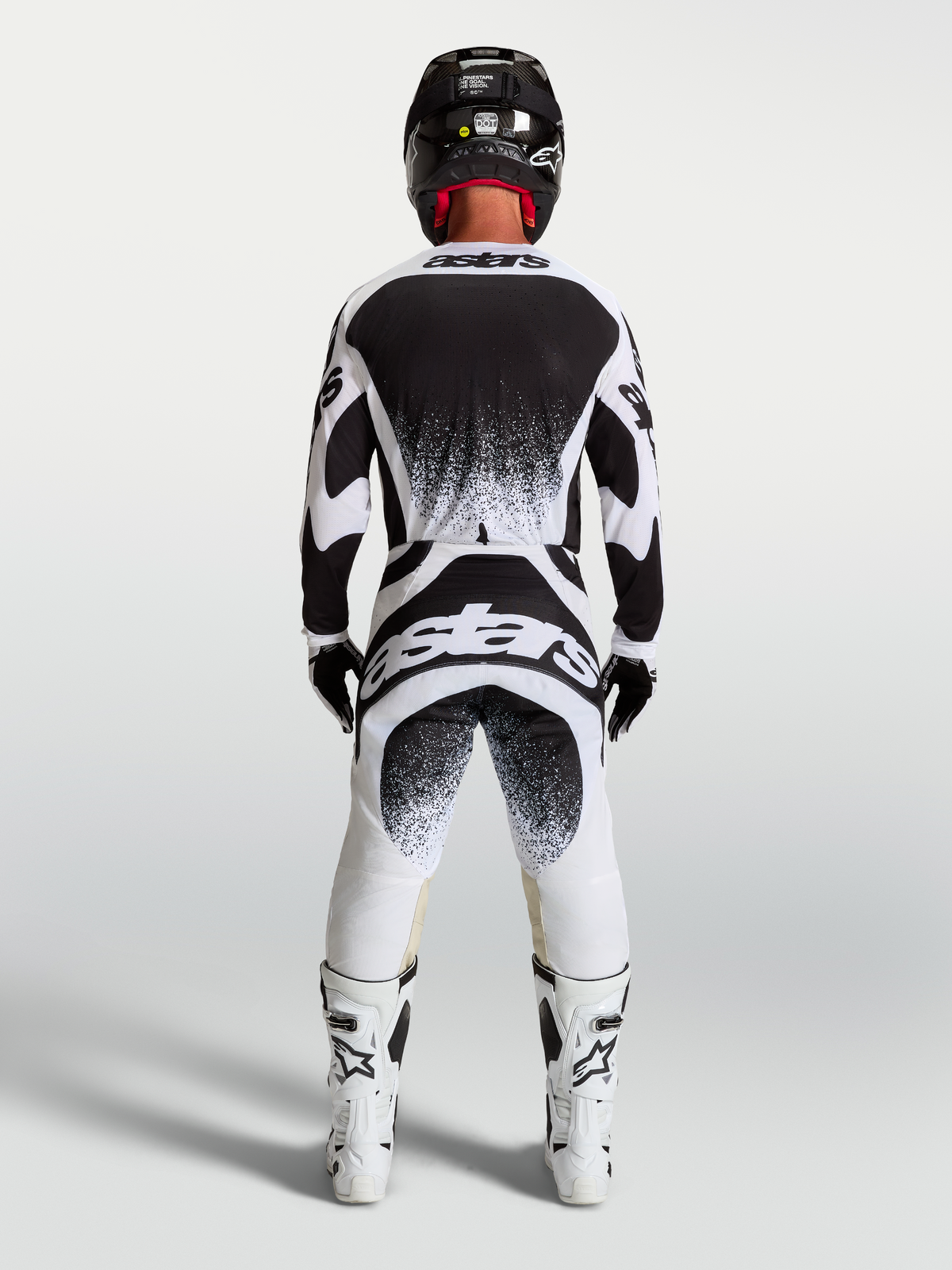 Alpinestars Techstar Swan broek en jersey, heren motorcrossuitrusting, zwart en wit, atletische racepasvorm met rugbranding.
